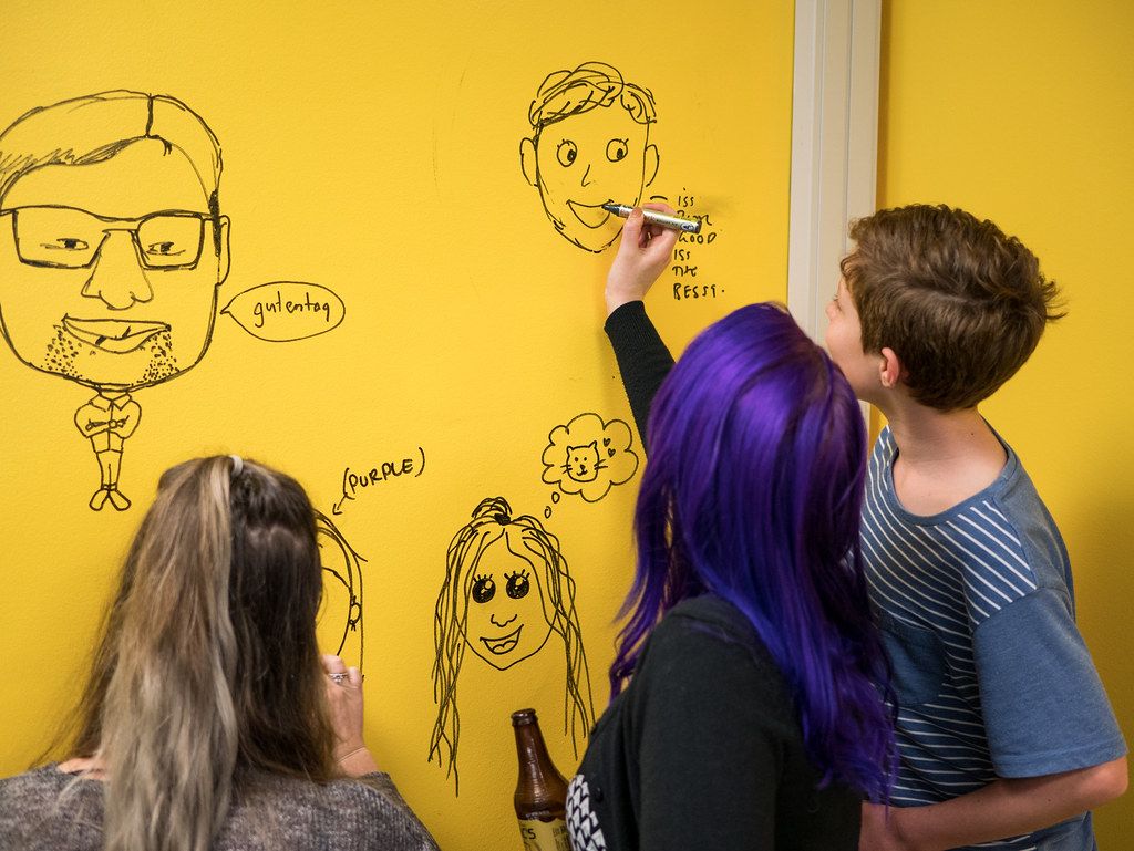 Engineers comparing three infrastructure options on a meeting-room whiteboard.