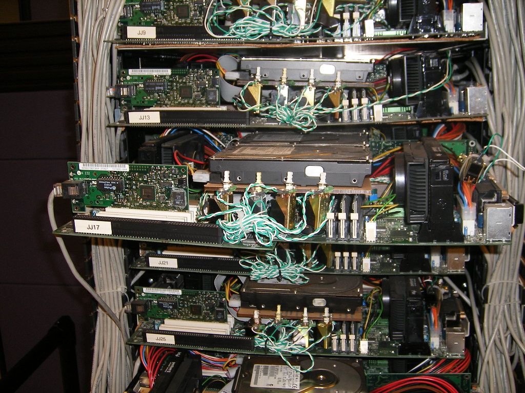 Two rows of server racks in a brightly lit data centre.